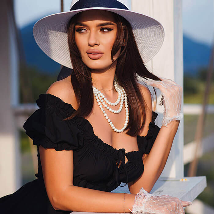 Woman in black dress and white sunhat