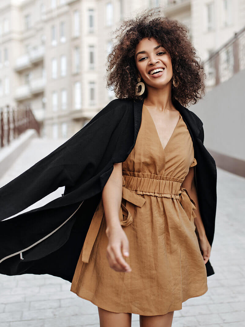 Curly haired woman in tan dress